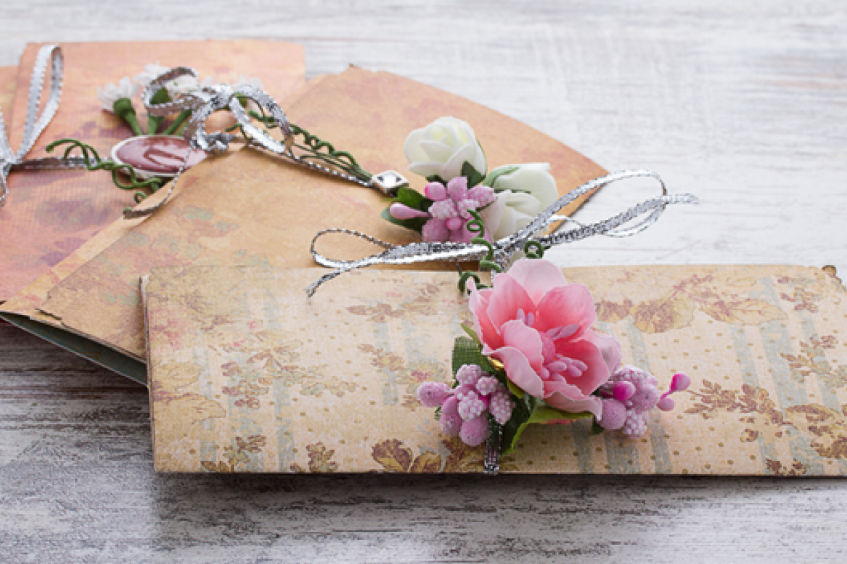 wedding invitations made of paper and flowers on wooden vintage background