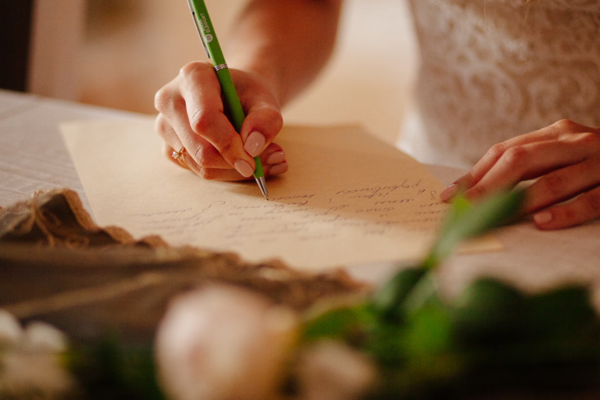 a close-up of a bride writing her wedding vows