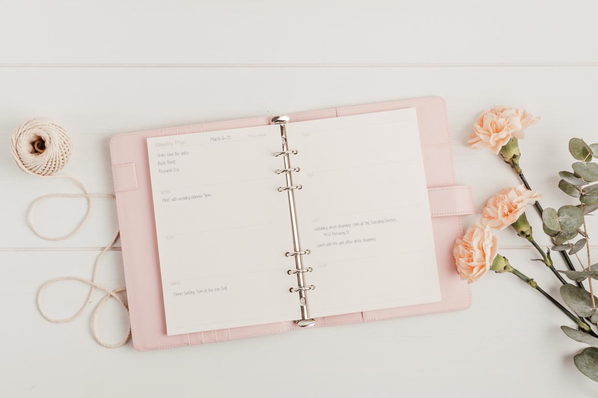 Wedding planner book laying open to a page with writing on it