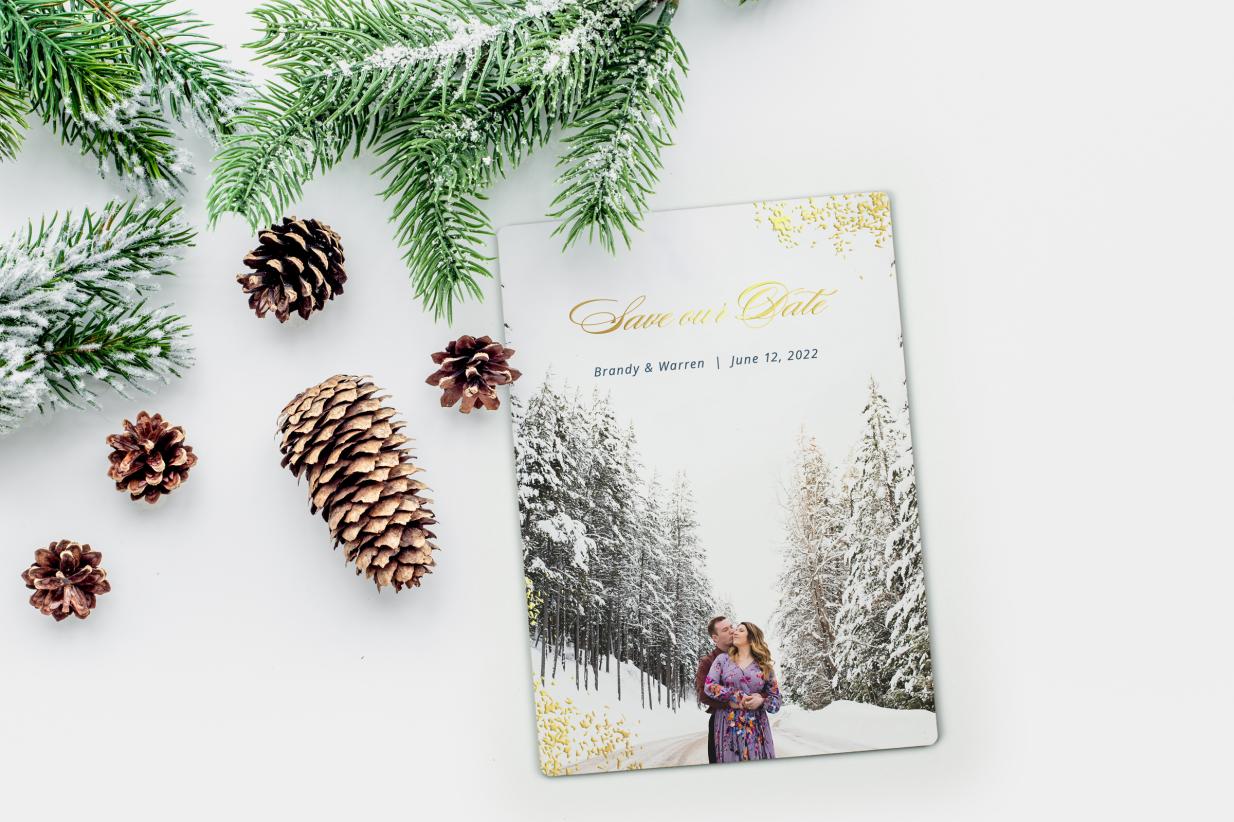 Winter Save the Dates with gold foil and evergreens