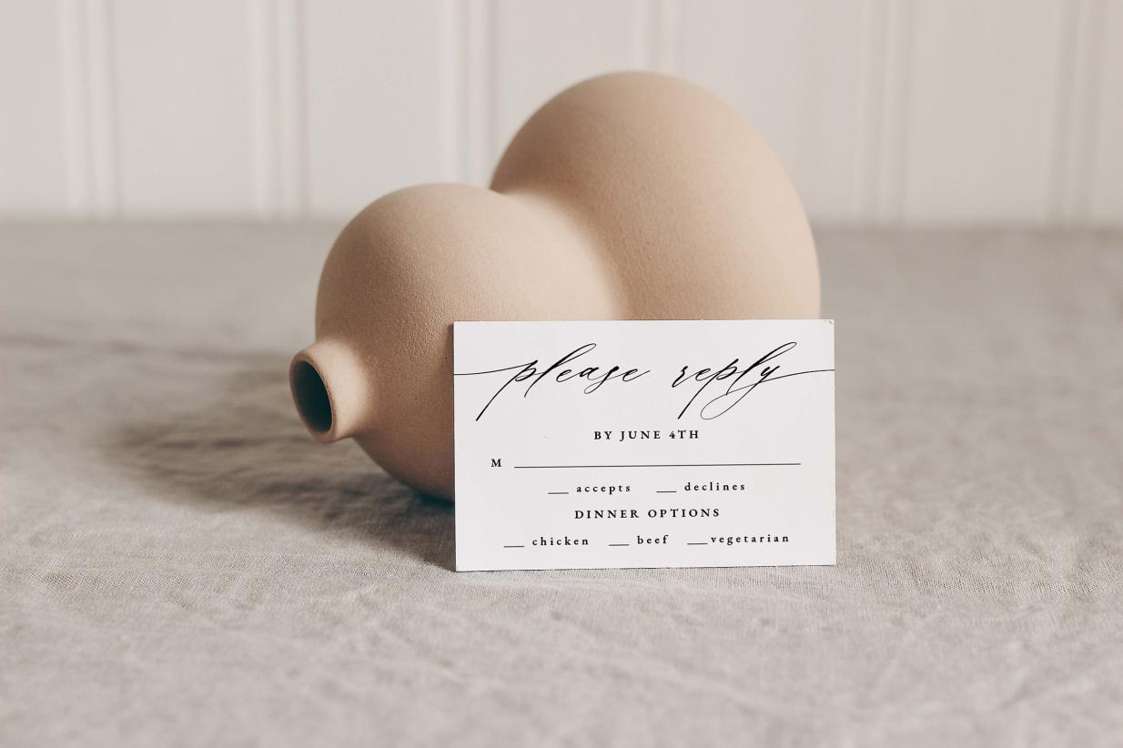Wedding response card leaning against vase