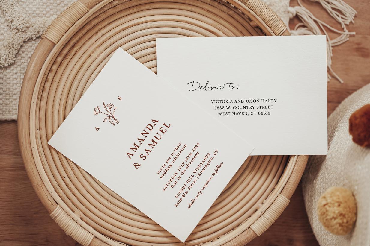 wedding invitation and addressed envelope laying on wooden tray