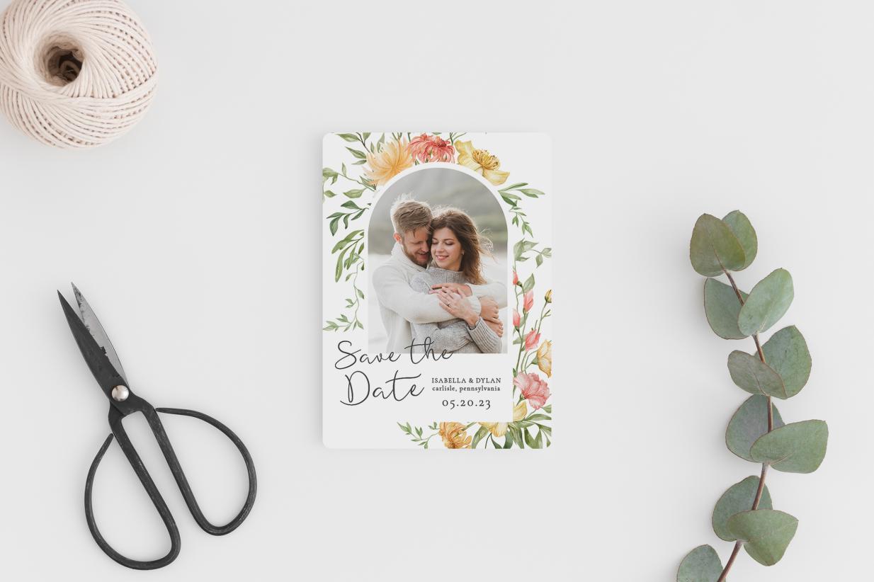 Save the date magnet next to eucalyptus sprig, scissors, and a ball of twine