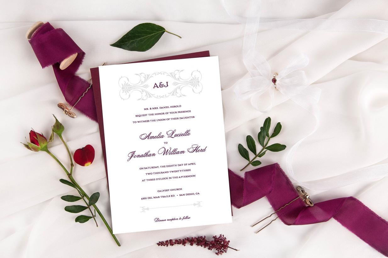 Wedding invitation on top of ribbon next to flowers and hair pin