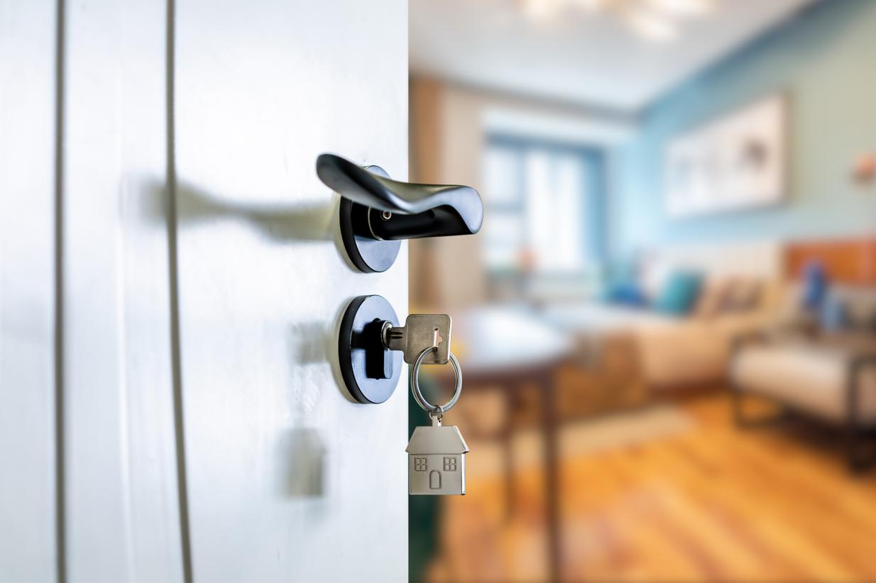 Real Estate symbol door with house key opening into room