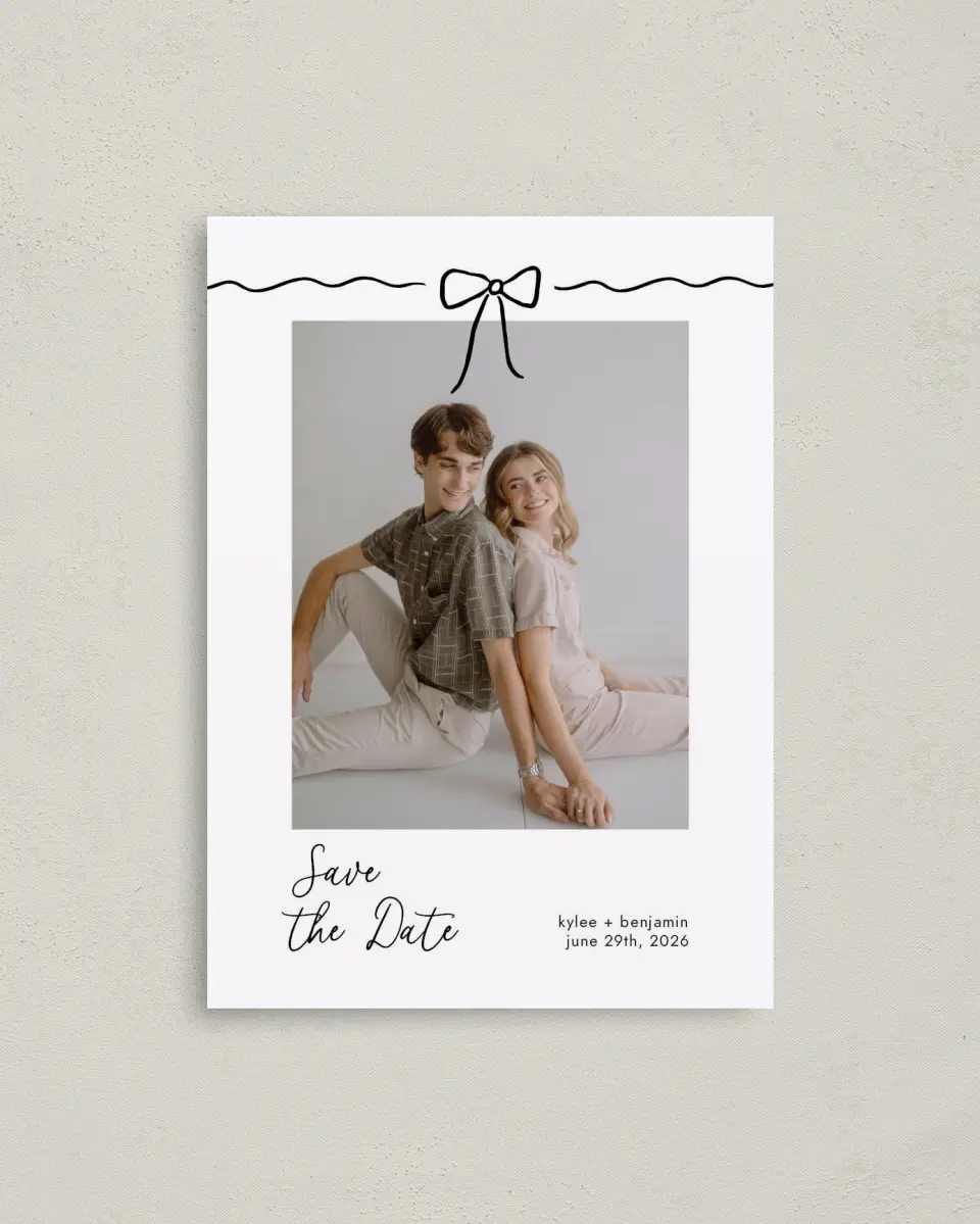 This is a 4" x 5.6" Save the Date Postcard called Bows and Bliss printed in full color with Rose Gold foil on Soft Touch Finish paper